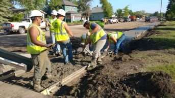 construction workers fixing water and sewer pipes along the road