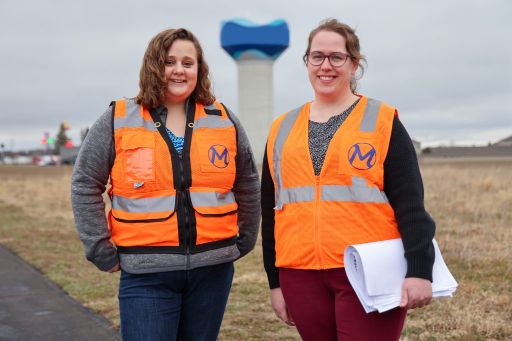 Two women standing in front of water tank